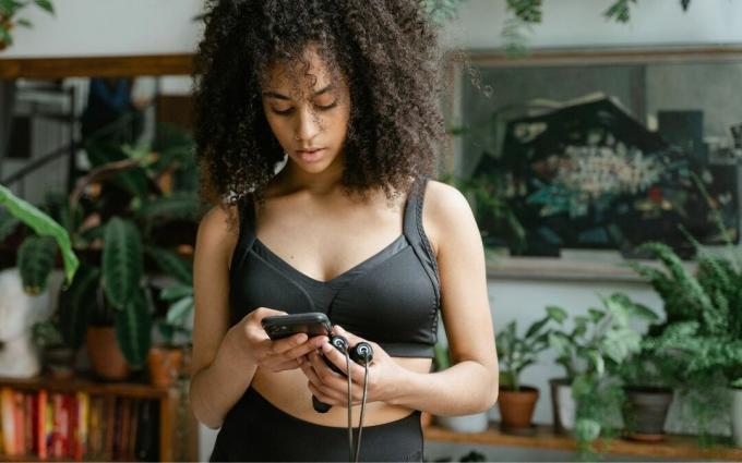 Wanita Memegang Ponsel dan Lompat Tali