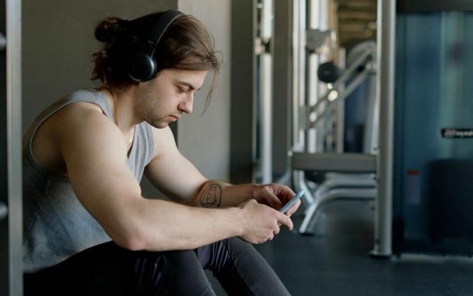 Pria Dengan Headphone Menggunakan Smartphonenya
