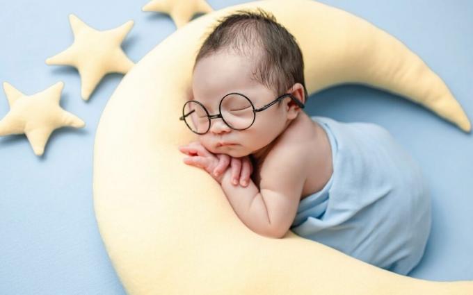 Bayi Tidur Lucu di atas bantal berbentuk bulan