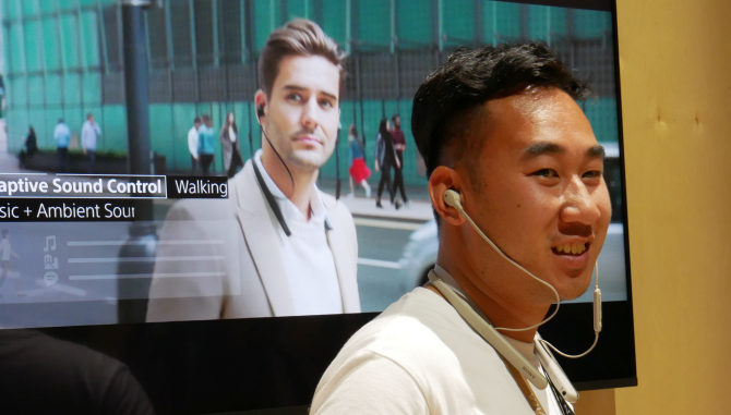 Karyawan Sonly mengenakan headphone Sony WI-1000XM2 di IFA 2019.