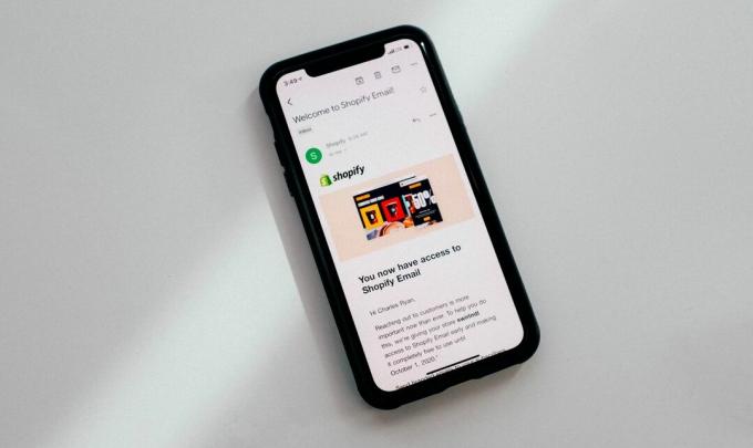 IPhone dengan permukaan putih menampilkan email di layar