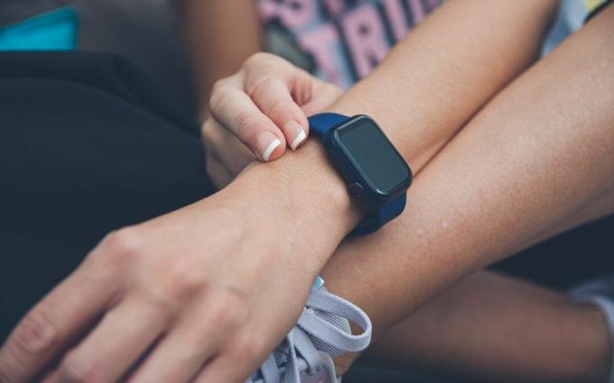 Orang yang Mengenakan Jam Tangan Pintar Biru dan Hitam